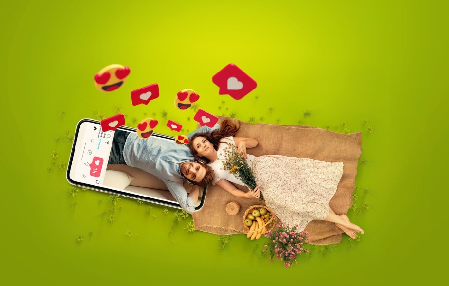 a couple laying together on virtual grass with virtual smiley faces and heart emojis floating around